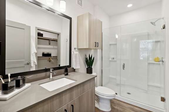 a bathroom with a sink toilet and a shower at The Depot Luxury Apartment Homes, Raymore, 64083