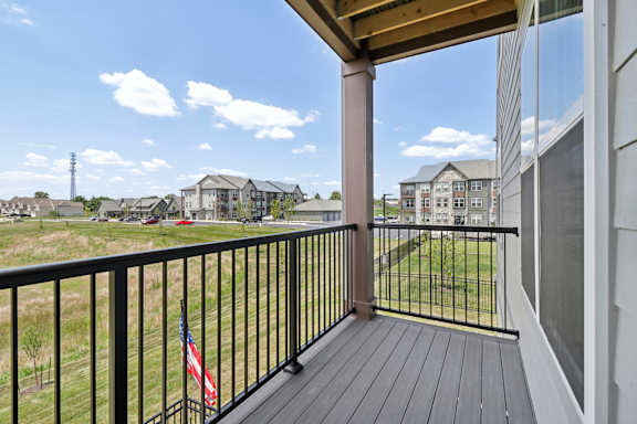 the view from the balcony of an apartment building with a flag on the balcony railing