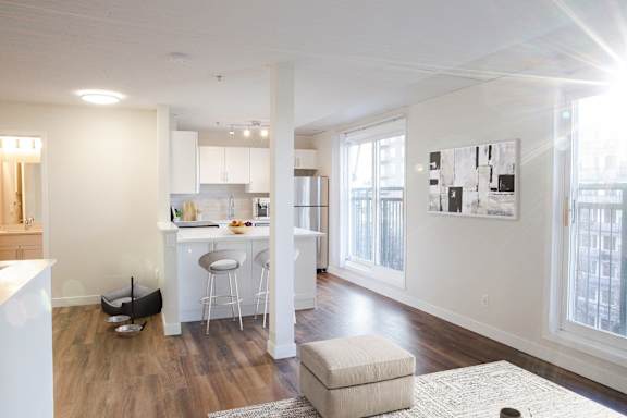 a living area with a kitchen and a bar and a window