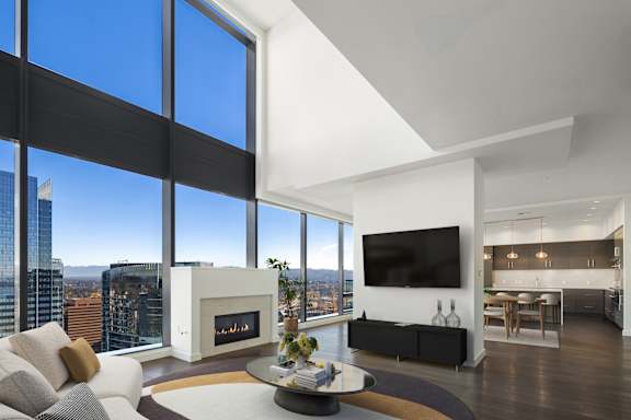 A modern living room at Two Lincoln Tower with a fireplace and a view of the Bellevue.