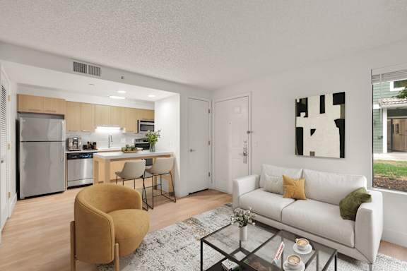 A modern living room with a white couch and a yellow chair. at AVIA Lofts on Parkway, Vancouver, 98662