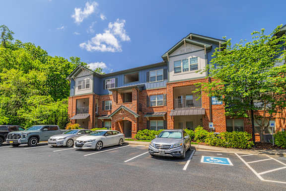 A parking lot with cars and a building in the background.