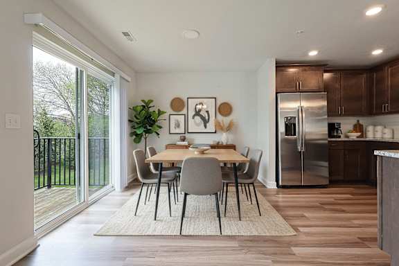 A modern kitchen with a dining table and chairs in the middle of the room.
