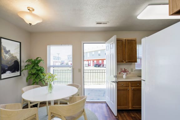 a dining room and kitchen with a door to a balcony and a table and chairs at Chariot Pointe Apartments, Tennessee