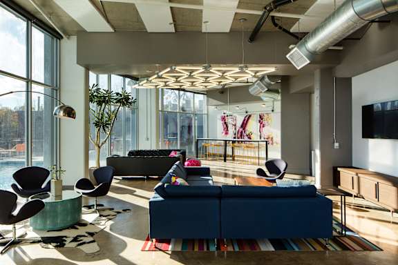 A modern living room with a blue couch and a large window.
