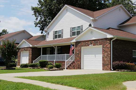 A house with a white garage door and a flag on the porch.
