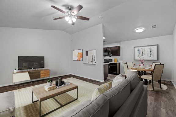 A living room with a grey couch and a wooden coffee table.