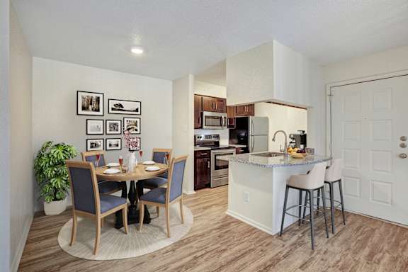 A kitchen with a dining table and chairs.
