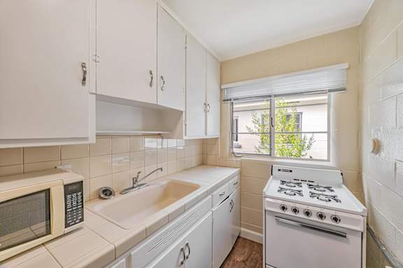A kitchen with white appliances and cabinets.