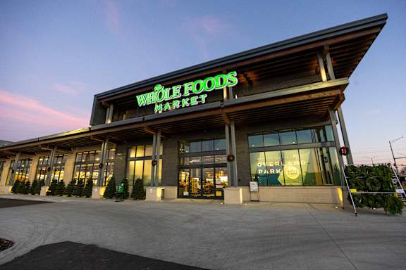 A Whole Foods Market storefront with a clear sky in the background.