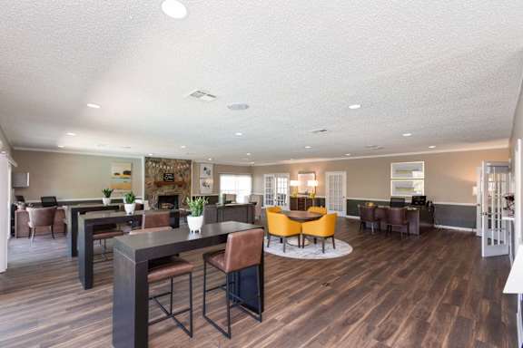 a community room with tables and chairs and a fireplace at Lakecrest Apartments, PRG Real Estate Management, Greenville, South Carolina