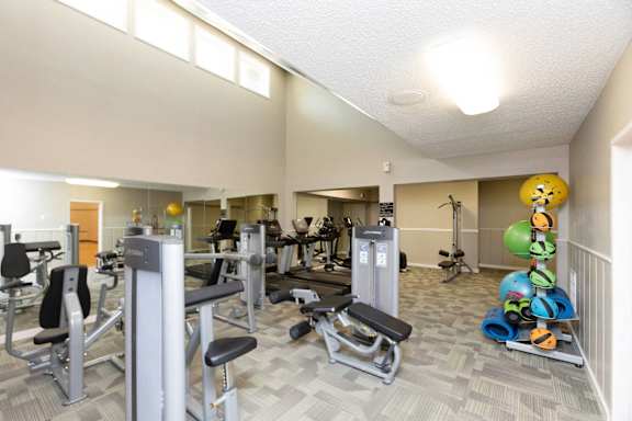 a gym with weights and cardio equipment at the village apartments at Lakecrest Apartments, PRG Real Estate Management, Greenville, South Carolina