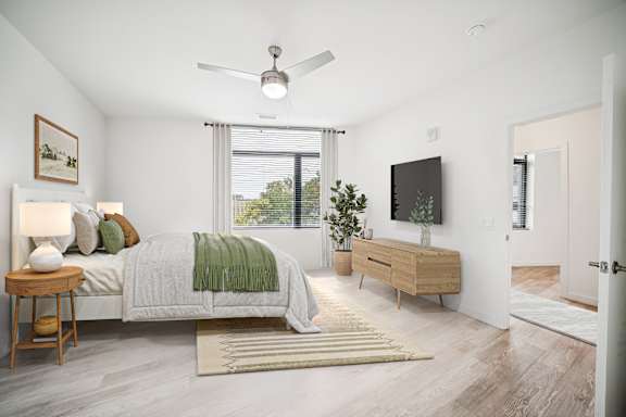 A bedroom with a bed, a side table, a dresser, and a ceiling fan.
