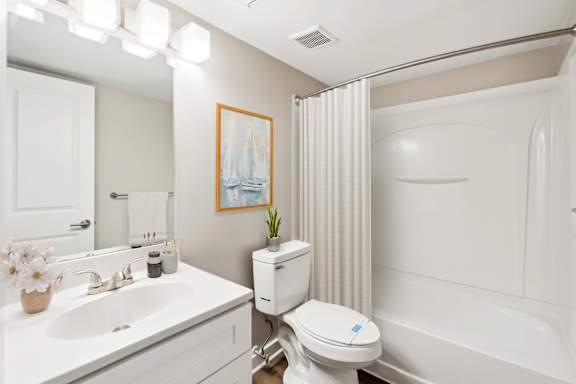 A white bathroom with a toilet, sink, and bathtub.