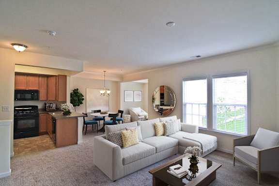A well-lit, spacious living room with a kitchen area in the background. at Barrington Park Apartments, Manassas, VA, 20110