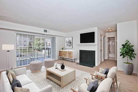 A living room with a fireplace, a white sofa, and a grey armchair. at Fairfax Square Apartments, Fairfax, VA, 22031