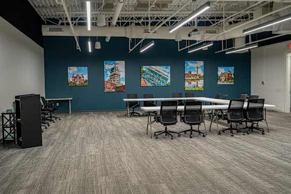 A conference room with a long table and chairs.