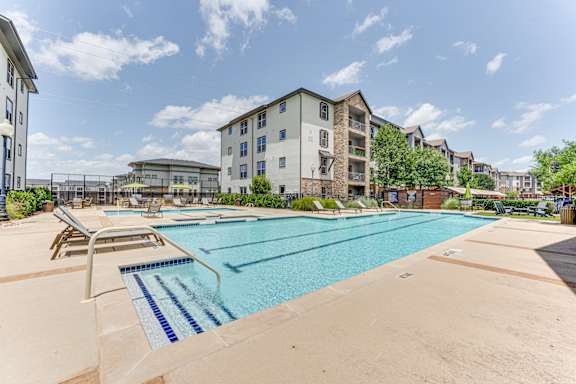 A large outdoor swimming pool with a diving board.