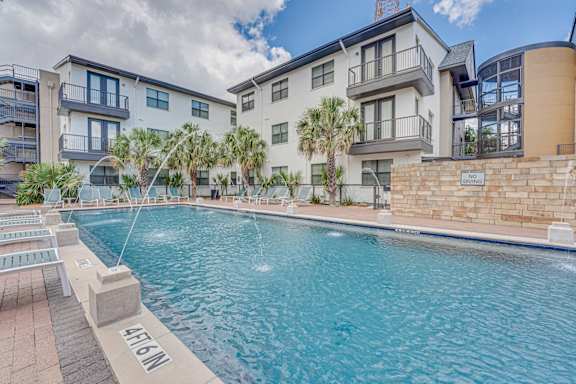 A swimming pool in front of a residential building.