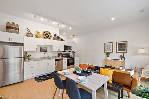 a living room and kitchen with a table and chairs at The Freelon at Sugar Hill, Detroit, MI 48201