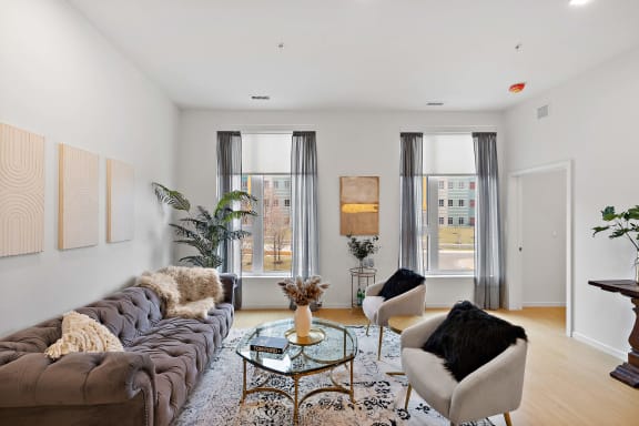 a living room with a couch and two chairs and two windows at The Freelon at Sugar Hill, Detroit, MI 48201