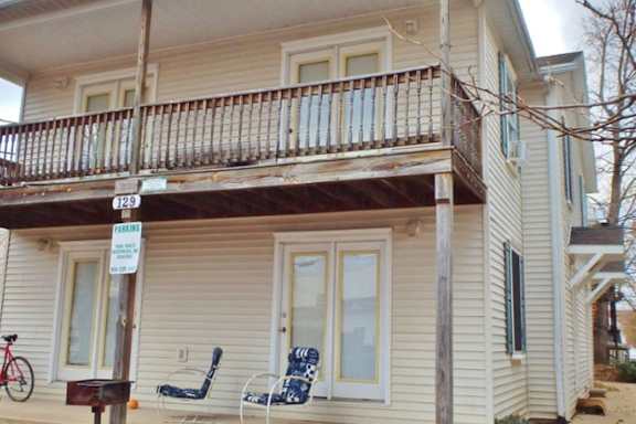 A house with a balcony and a bicycle parked outside.