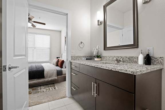 A bathroom with a vanity and a mirror. at West 39th Street Apartments, Kansas City, 64111