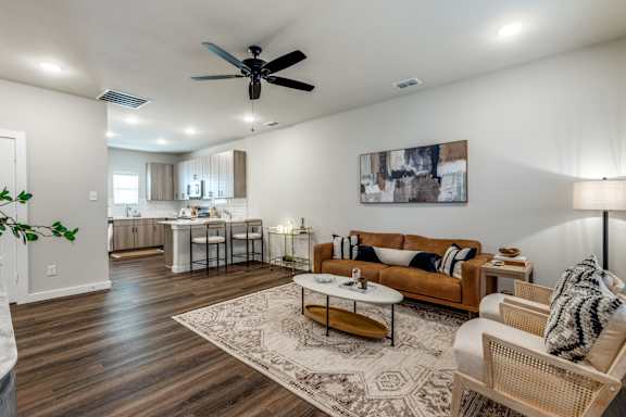 A living room with a brown sofa and a white coffee table.