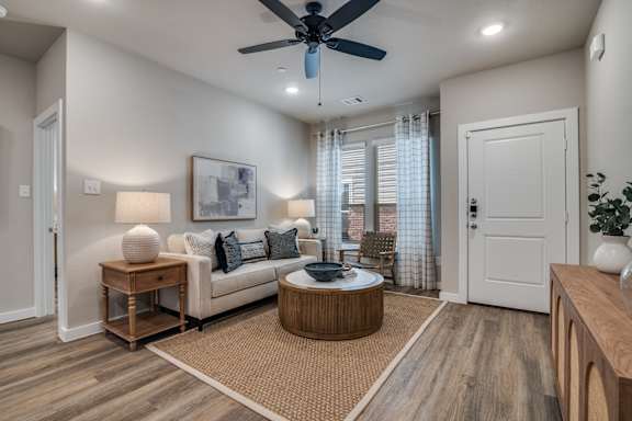 A modern living room with a ceiling fan and a white couch.