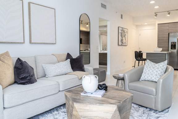 A modern living room with a grey couch, a coffee table, and a chair.