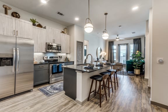a kitchen with stainless steel appliances and a large island with stools