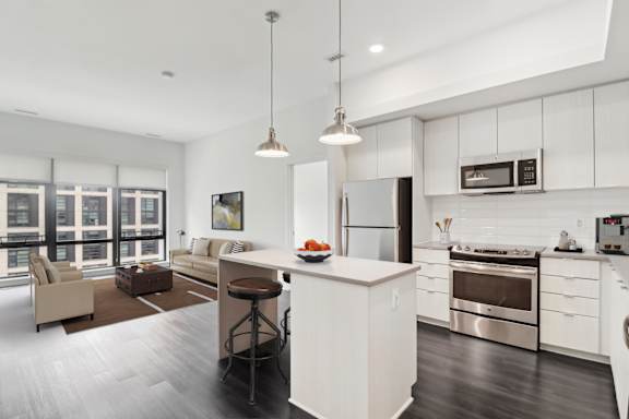 A modern kitchen with a bar stool and a dining table.