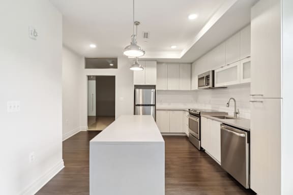 A modern kitchen with white cabinets and stainless steel appliances.