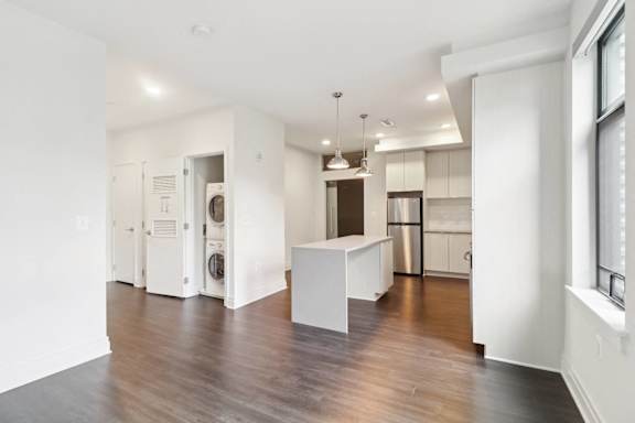 A white kitchen with a wooden floor and a white island.
