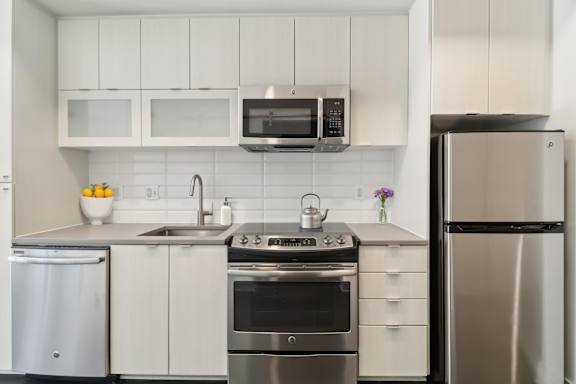 A modern kitchen with stainless steel appliances and white cabinets.