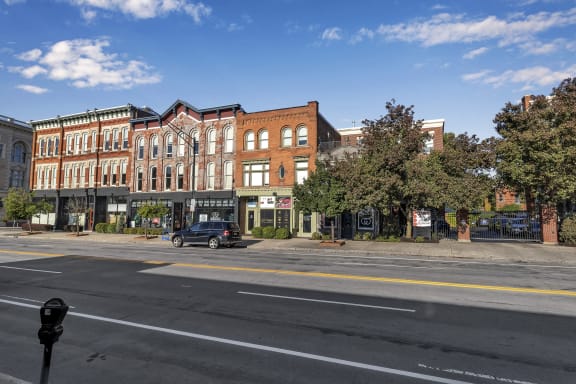 a city street with a car parked in front of a building at The Granite Works Apartments , Buffalo, 14202