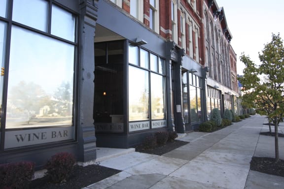 a sidewalk in front of a wine bar on a city street at The Granite Works Apartments , New York