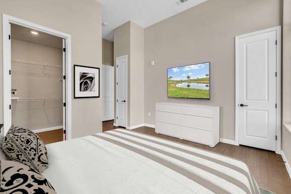 A bedroom with a large bed and a television on a cabinet.