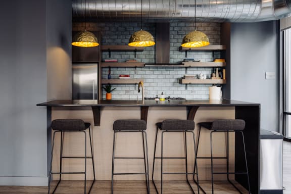 a kitchen with a counter with four stools and a counter top