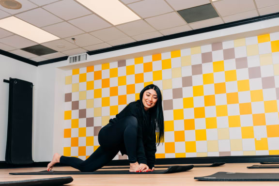 a woman doing yoga in a room with a yellow and white wall  at Vision on Lombard, Baltimore, MD