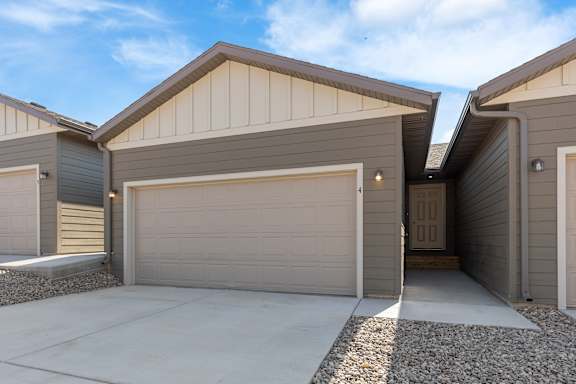 A modern house with a garage door open.