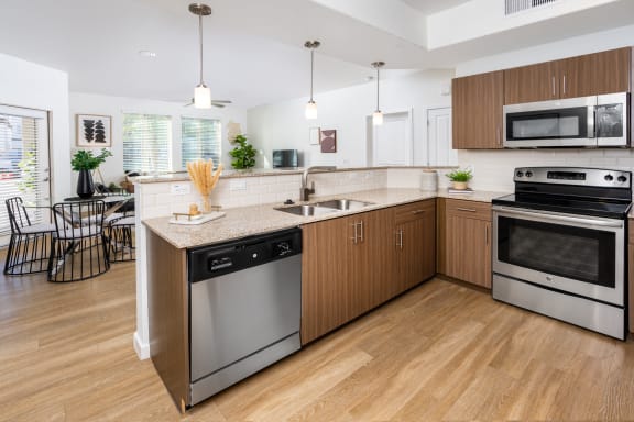 Kitchen with Wood-Cabinets, Wood-Style Flooring, and Stainless-Steel Appliances at Monument, Chandler