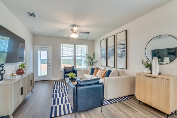 the living room of an apartment with a blue couch and a blue rug