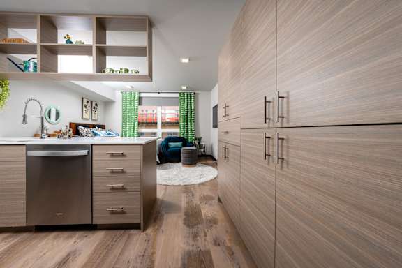 A modern kitchen with wooden cabinets and a stainless steel dishwasher.