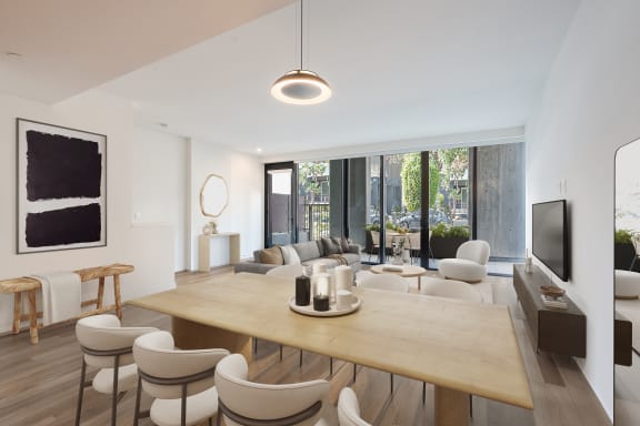 a living room and dining room with a wooden table and chairs