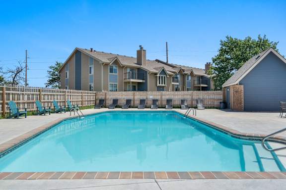 A large swimming pool in front of a house.