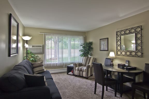 Furnished living room with wall decor, table, and chairs
