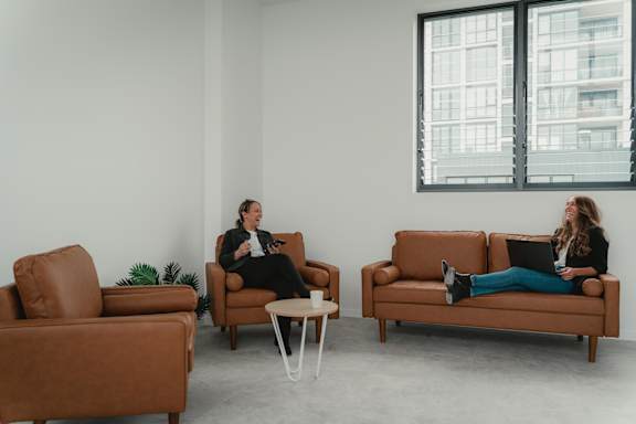 two women sitting on couches in a living room