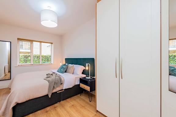 a bedroom with a bed and white cabinets