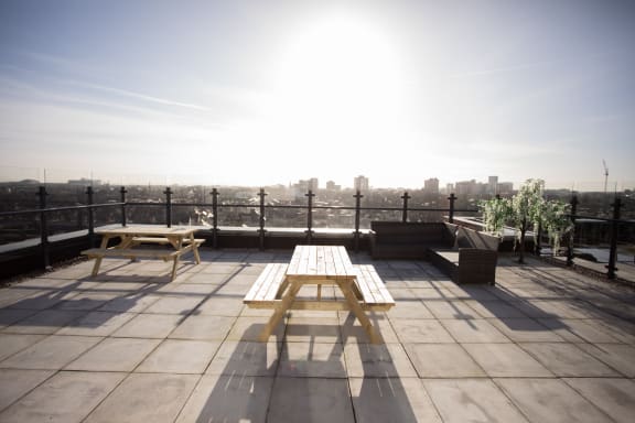 a picnic table on a roof terrace with a view of the city